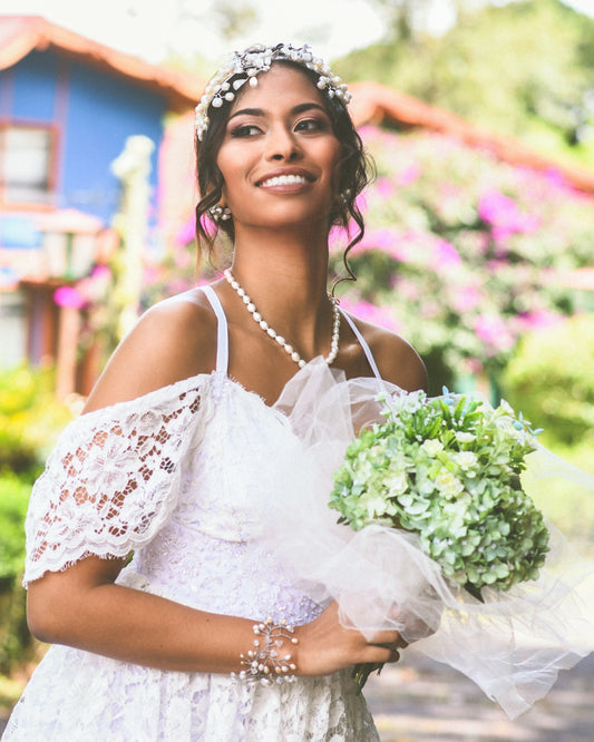 woman in white floral dress holding bouquet of flowers