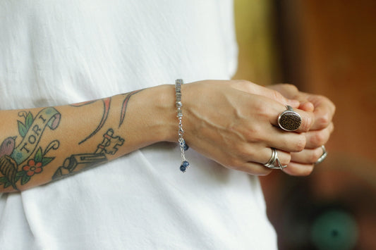 a woman with a tattoo on her arm holding onto a bracelet