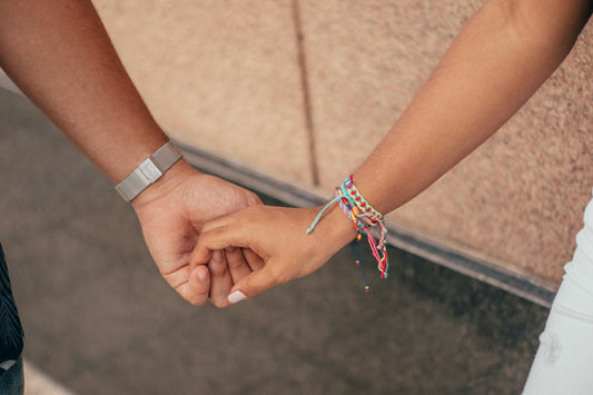 a close up of two people holding hands