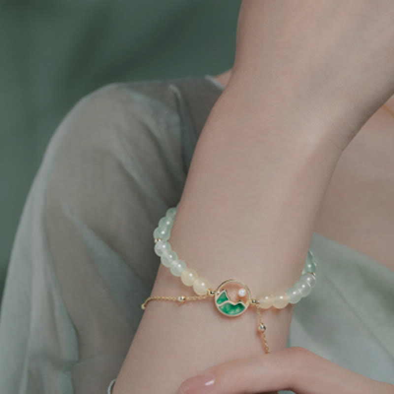 Conjunto de collar y pulsera con colgante de la suerte, piedras de Buda, cobre bañado en oro de 18 quilates, jade natural y calcedonia. Un panorama de ríos y montañas.