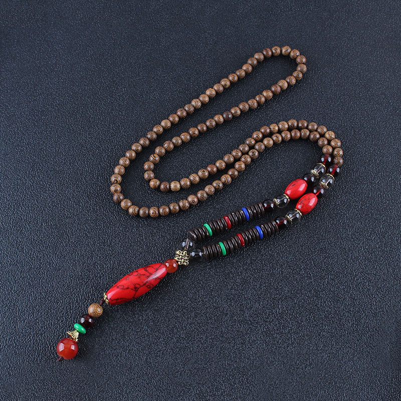 Collar con colgante de piedra turquesa, madera de wengué y piedras de Buda que protegen la calma.