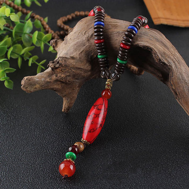Collar con colgante de piedra turquesa, madera de wengué y piedras de Buda que protegen la calma.
