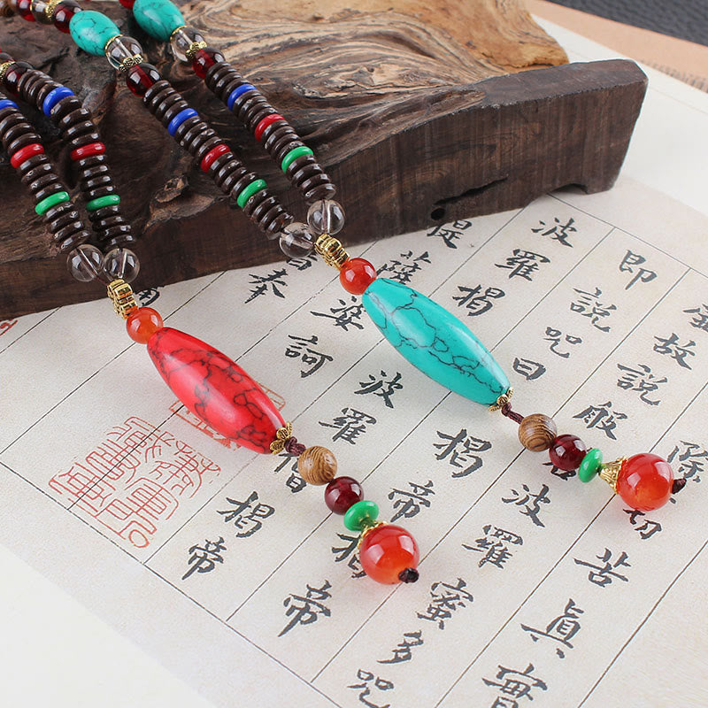 Collar con colgante de piedra turquesa, madera de wengué y piedras de Buda que protegen la calma.
