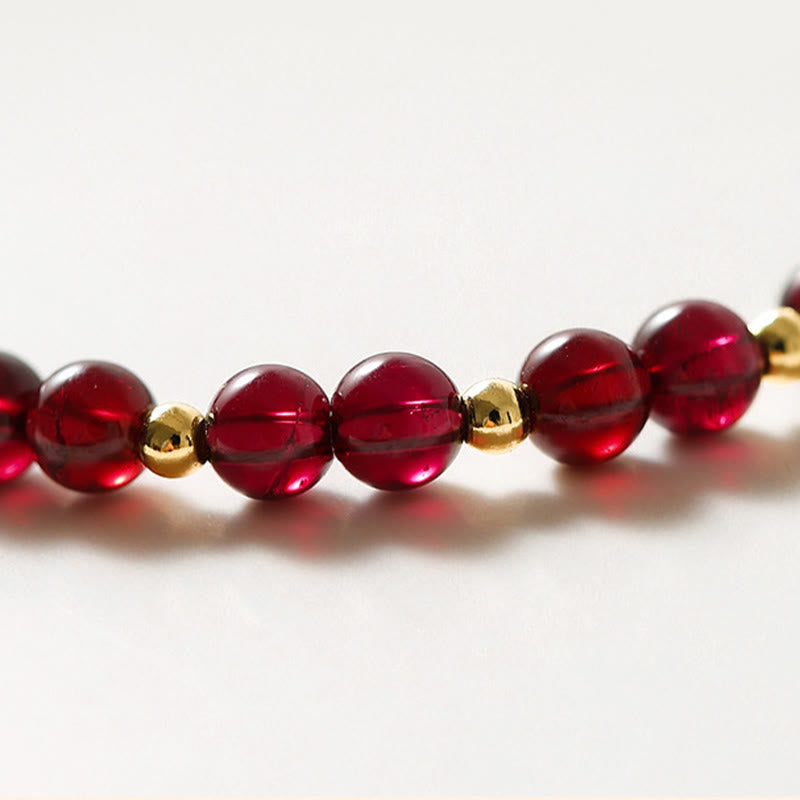 Pulsera Buddha Stones de oro de 14 quilates con flor de cinabrio y granate natural.