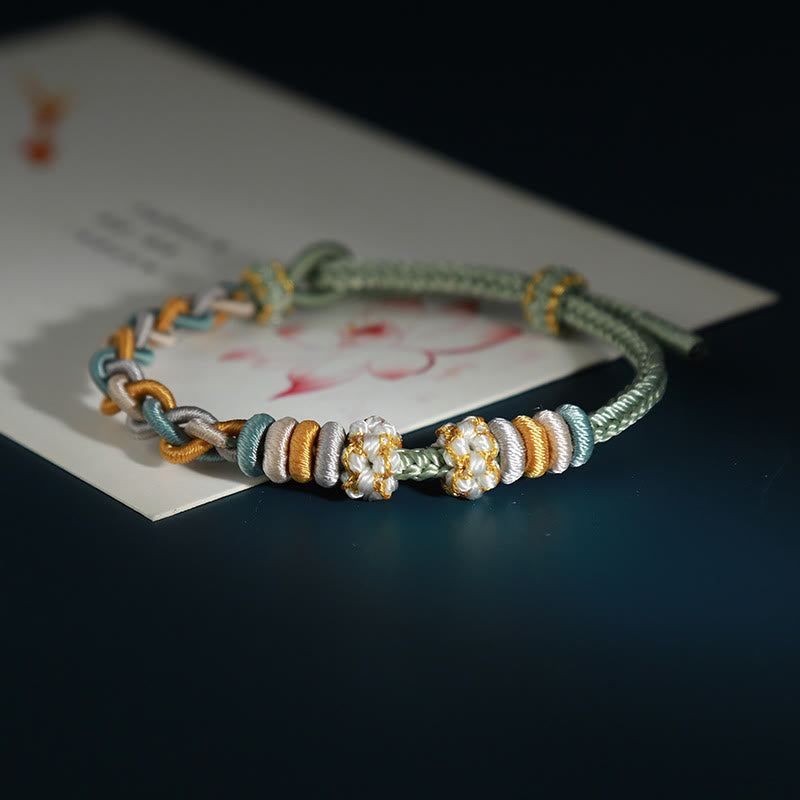 Pulsera de cuatro hilos con piedras de Buda y flor de durazno