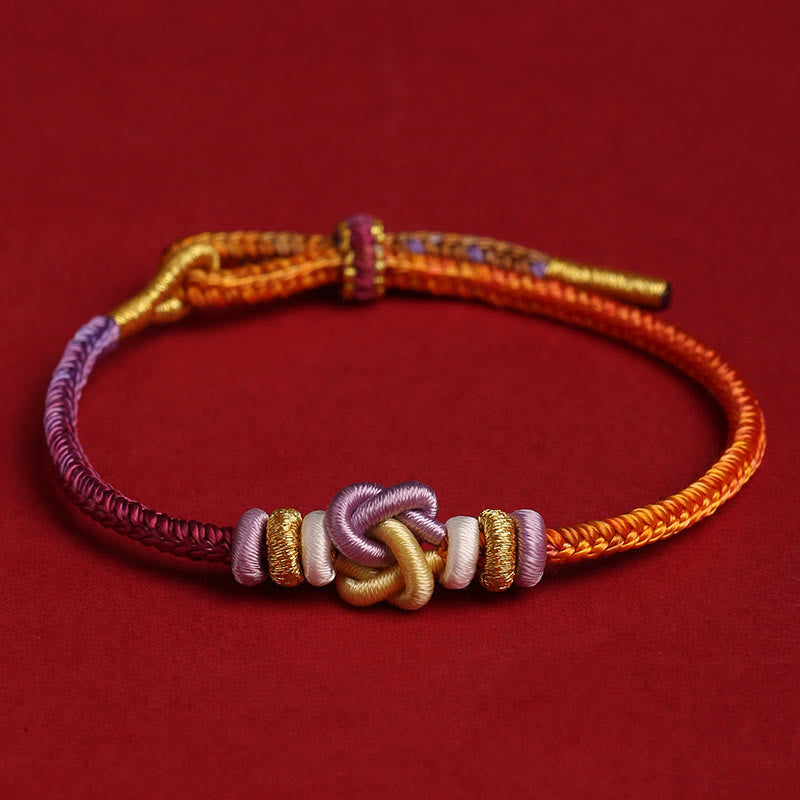 Pulsera trenzada con nudo de corazón y piedras de Buda de colores