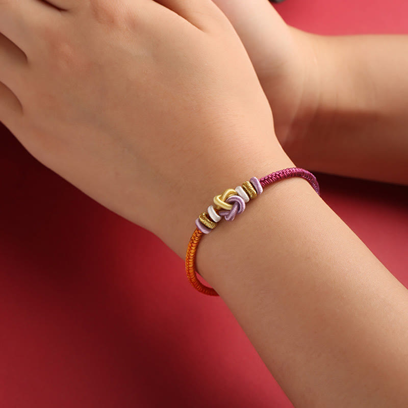 Pulsera trenzada con nudo de corazón y piedras de Buda de colores