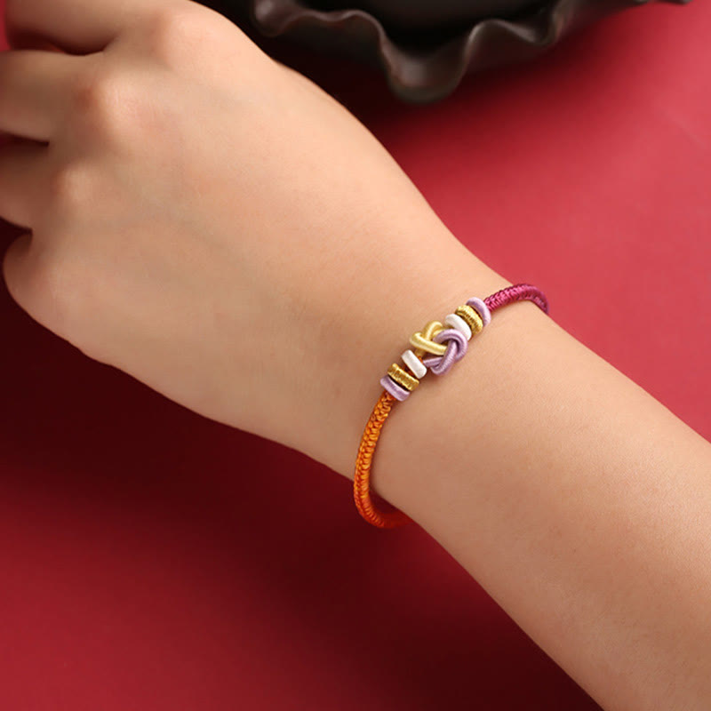 Pulsera trenzada con nudo de corazón y piedras de Buda de colores