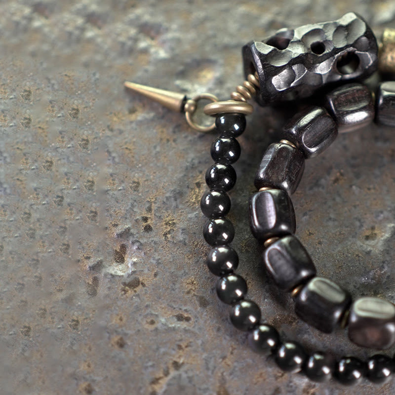 Pulsera de doble vuelta con piedras de Buda, madera de ébano, obsidiana negra, cobre y latón.