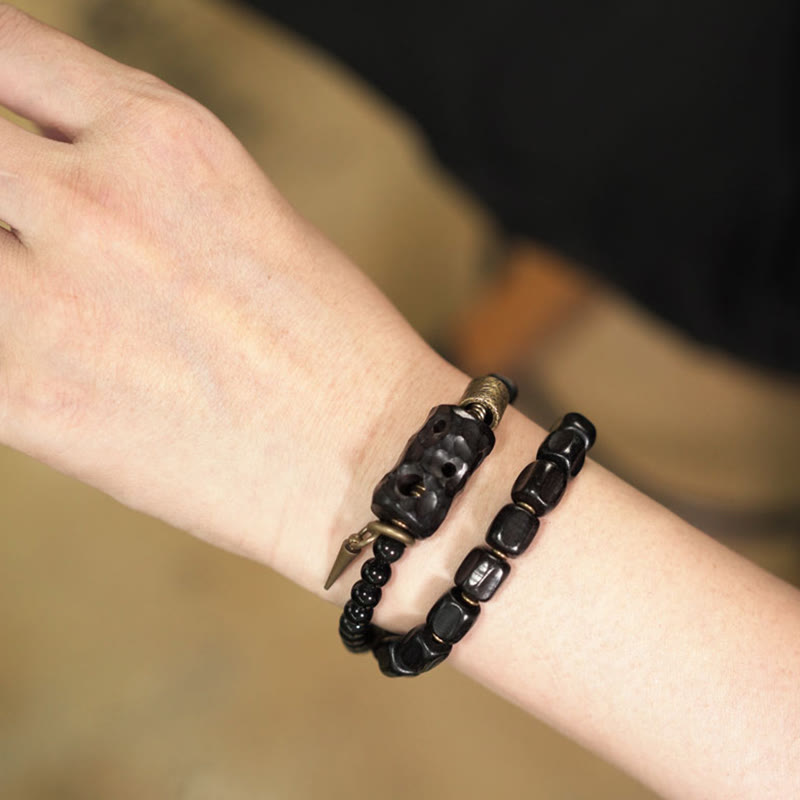 Pulsera de doble vuelta con piedras de Buda, madera de ébano, obsidiana negra, cobre y latón.