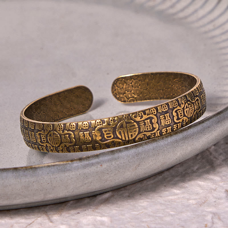 Pulsera de la suerte de cobre y latón con el símbolo Fu de las Cien Bendiciones de Buda