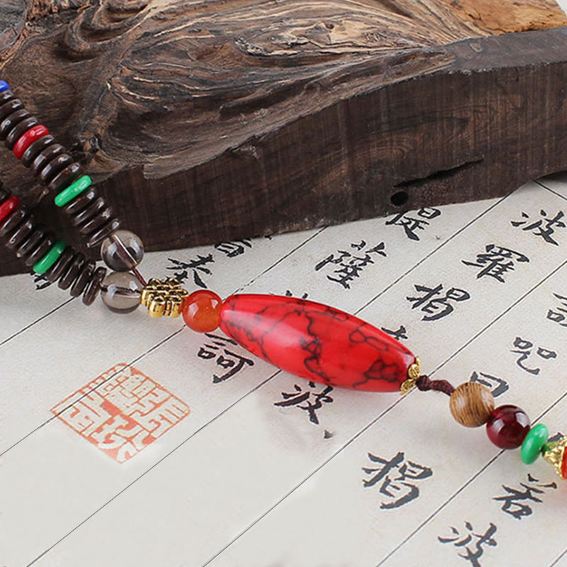 Collar con colgante de piedra turquesa, madera de wengué y piedras de Buda que protegen la calma.