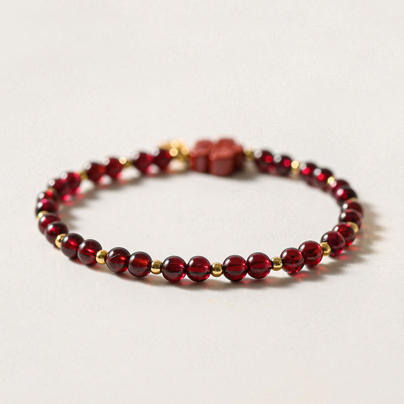 Pulsera Buddha Stones de oro de 14 quilates con flor de cinabrio y granate natural.