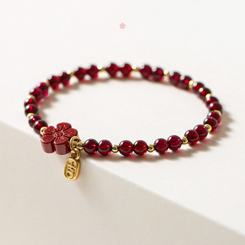 Pulsera Buddha Stones de oro de 14 quilates con flor de cinabrio y granate natural.