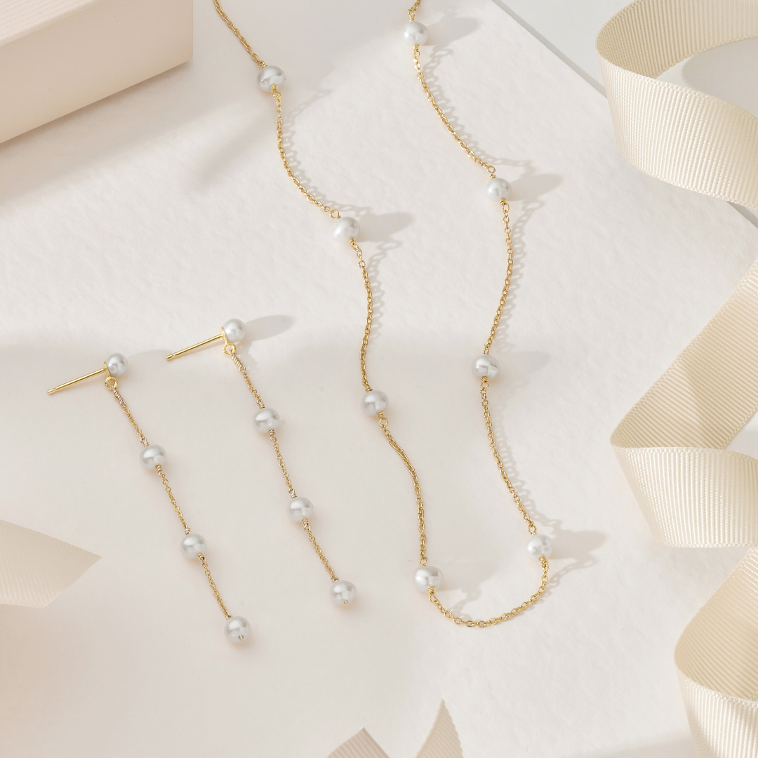 Geschenkset aus goldenen Tropfenohrringen mit vier Perlen und einer Halskette mit zehn Perlen