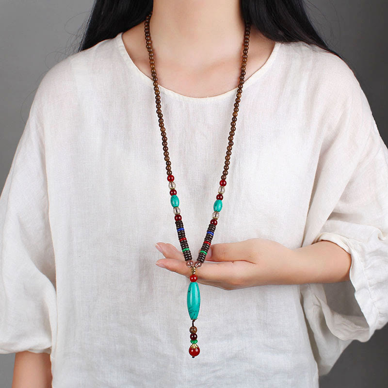 Collar con colgante de piedra turquesa, madera de wengué y piedras de Buda que protegen la calma.