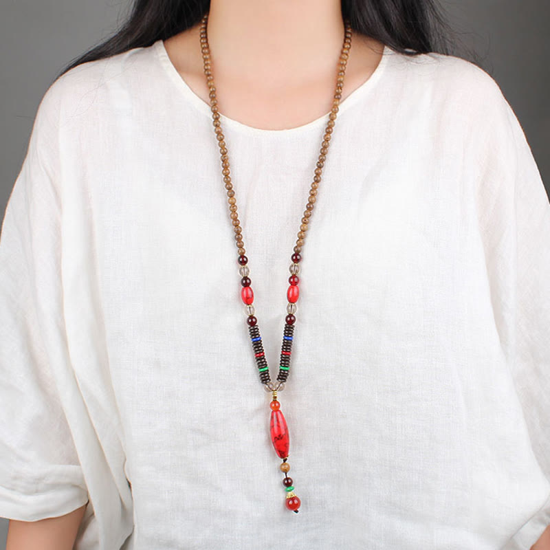 Collar con colgante de piedra turquesa, madera de wengué y piedras de Buda que protegen la calma.