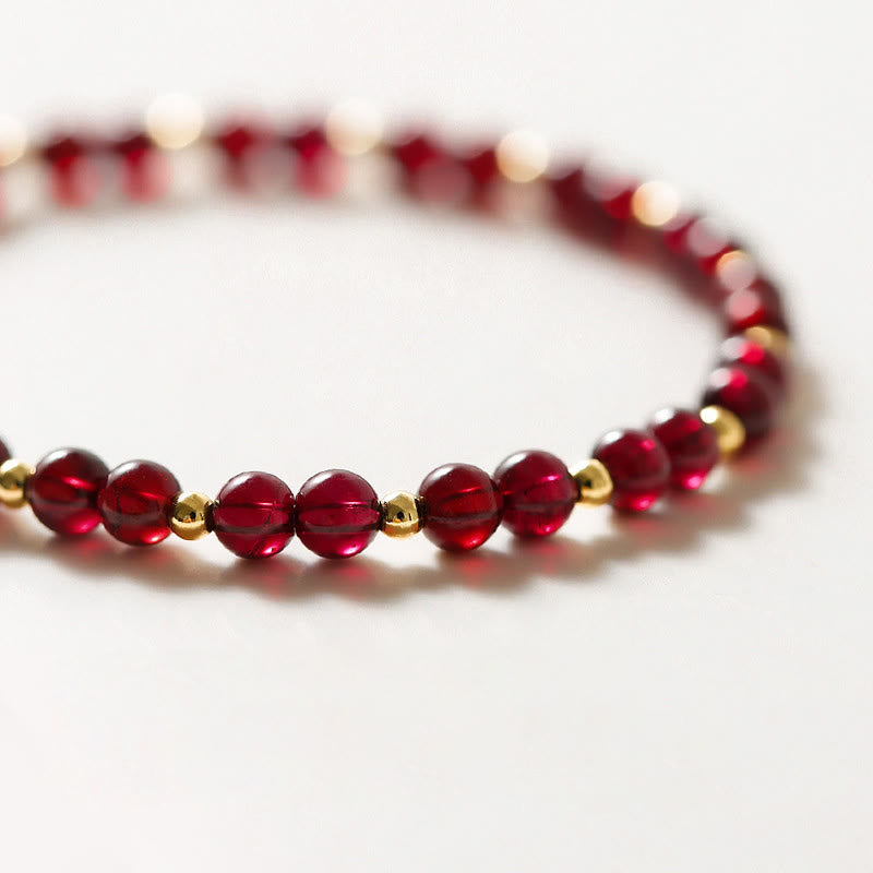 Pulsera Buddha Stones de oro de 14 quilates con flor de cinabrio y granate natural.