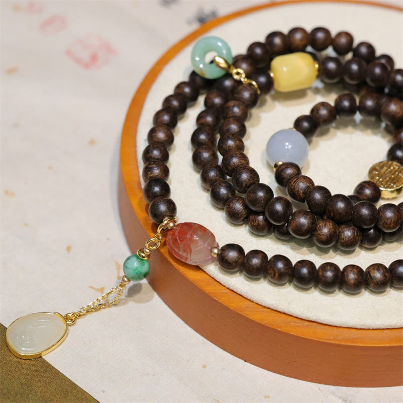 Pulsera de la paz con 108 cuentas de mala de Buda, madera de agar de Brunei, ámbar, ágata roja y jade con hebilla de la paz.