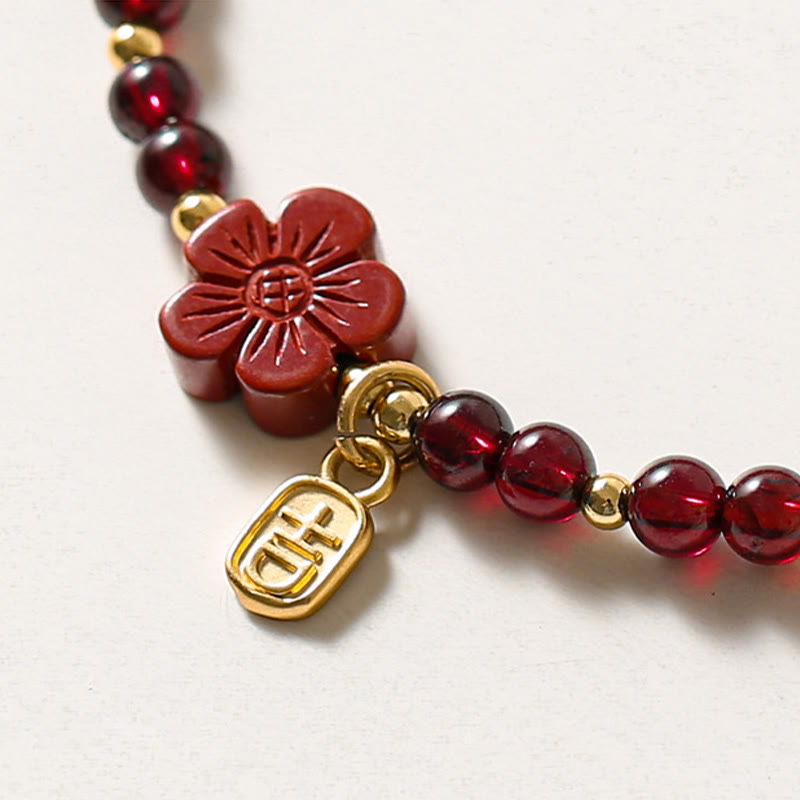 Pulsera Buddha Stones de oro de 14 quilates con flor de cinabrio y granate natural.