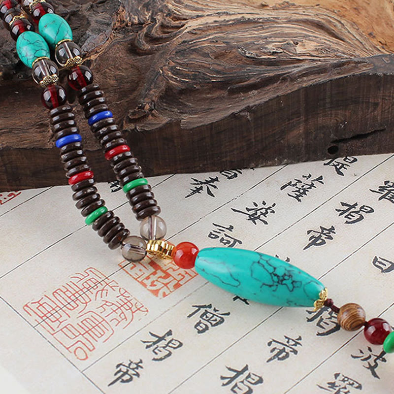 Collar con colgante de piedra turquesa, madera de wengué y piedras de Buda que protegen la calma.