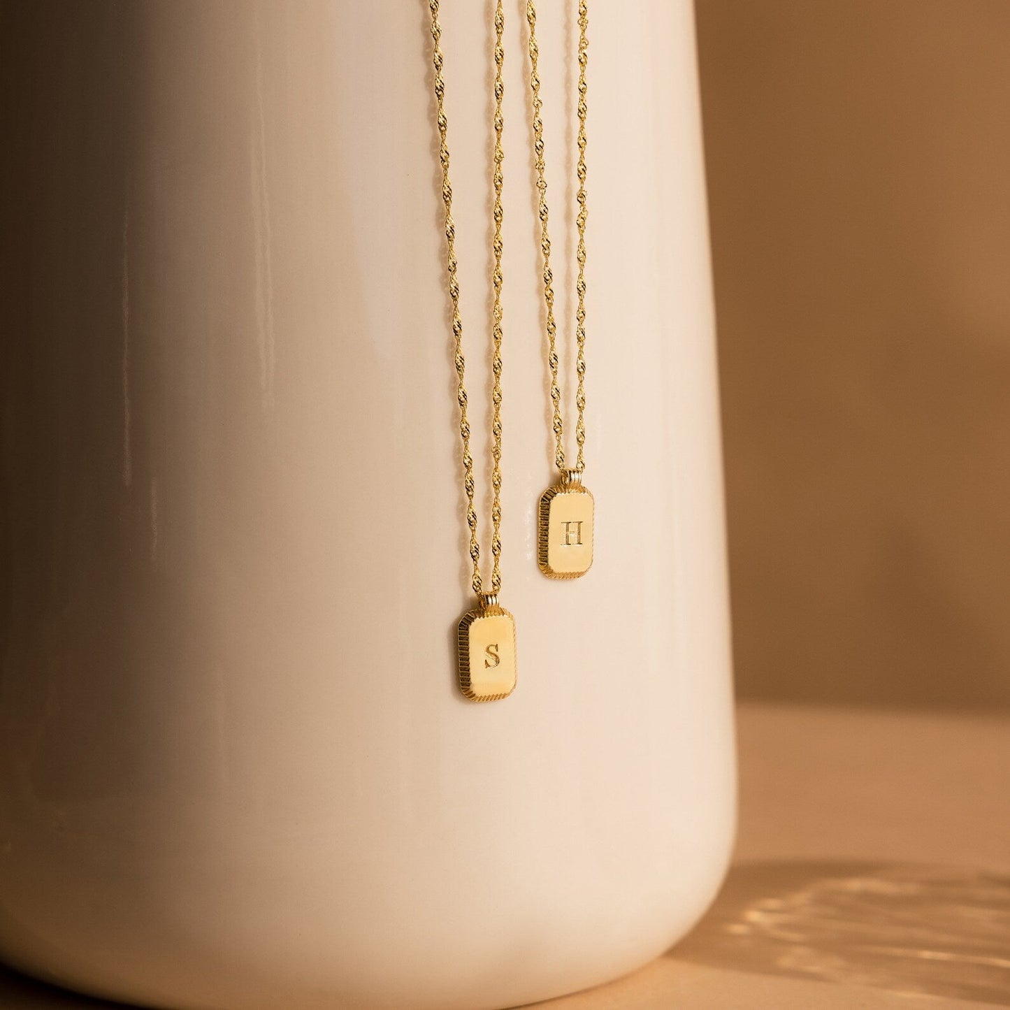 Collar con inicial acanalada y boletín informativo