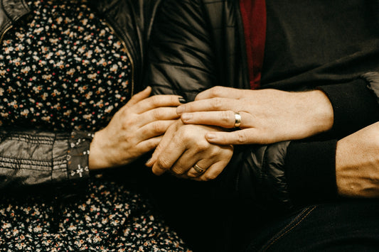 a close up of two people holding hands