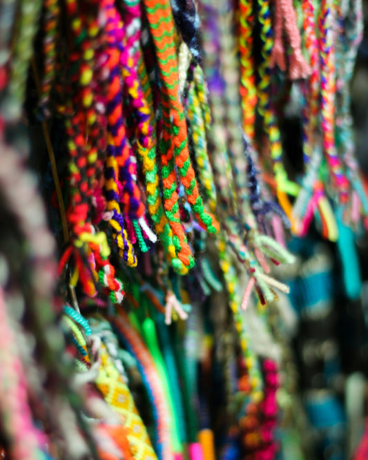 a bunch of bracelets are hanging on a wall