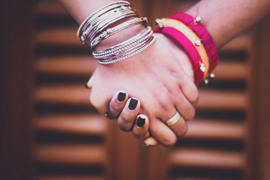 person wearing silver and gold bracelets