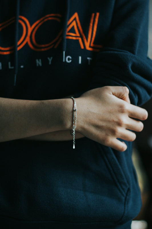 person wearing silver bracelet and blue shirt