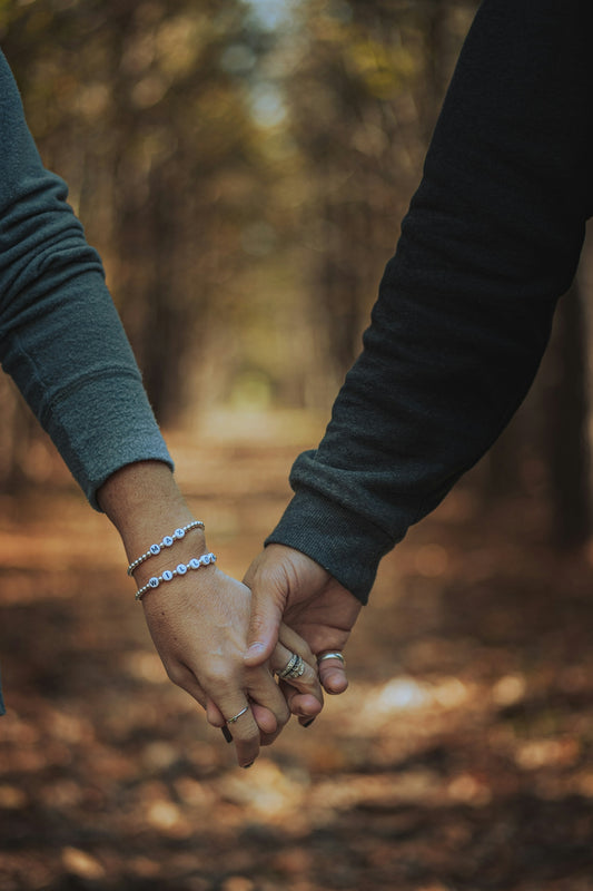 person in blue long sleeve shirt holding hands with woman in black long sleeve shirt