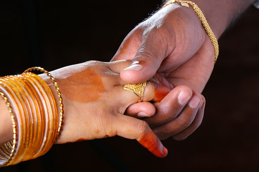 person wearing gold ring and gold bracelet