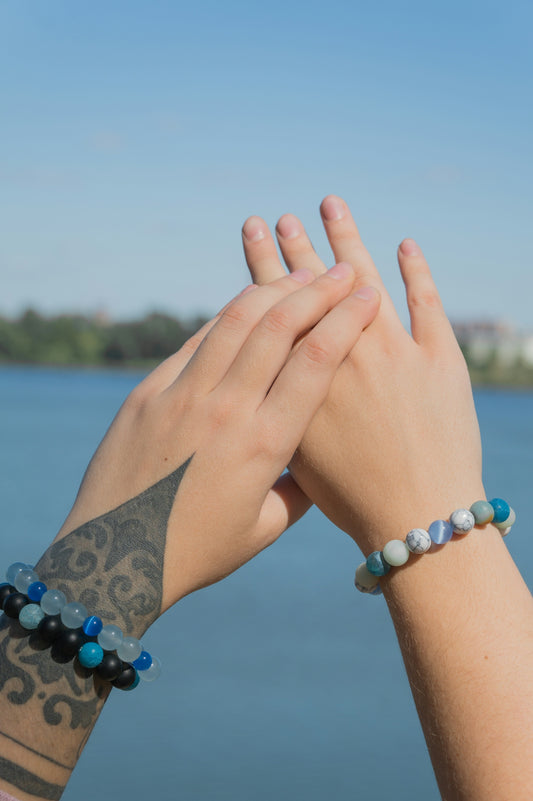 two hands holding each other with a lake in the background