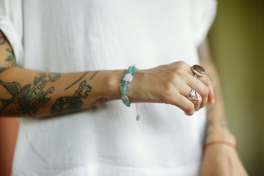 a person with tattoos on their arm holding something