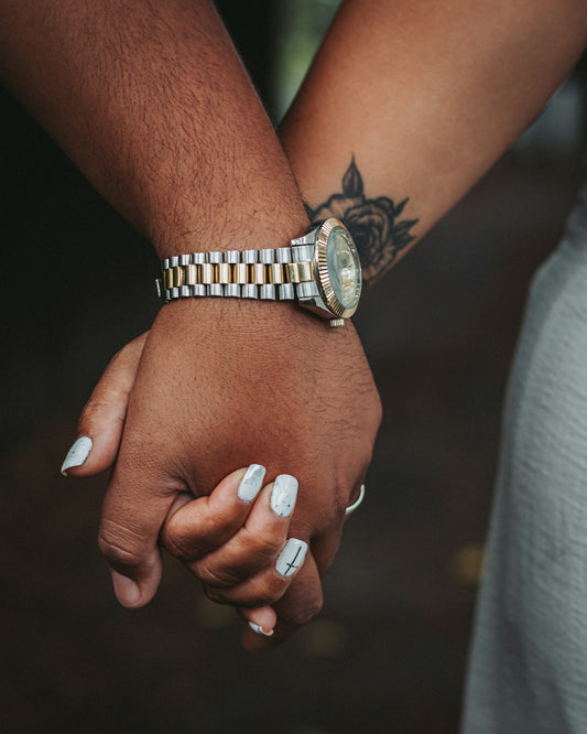 a close up of two people holding hands