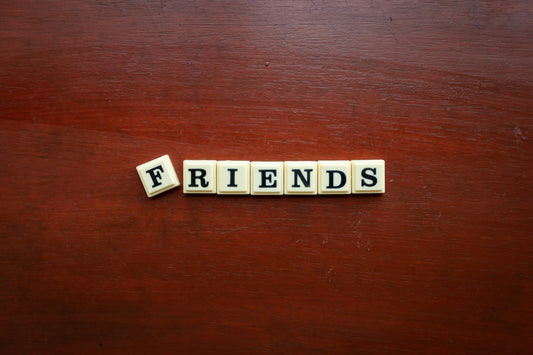 the word friends spelled with scrabbles on a wooden surface