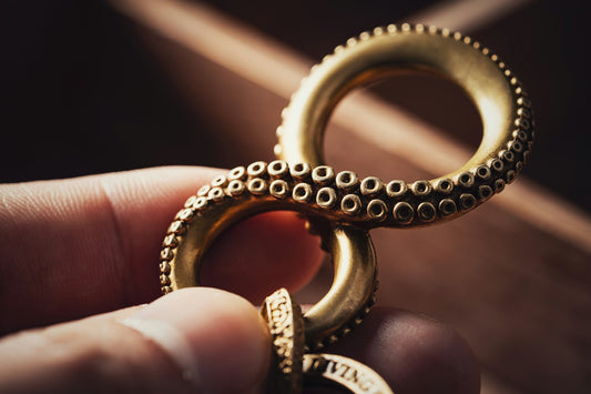 a person holding a gold ring in their hand