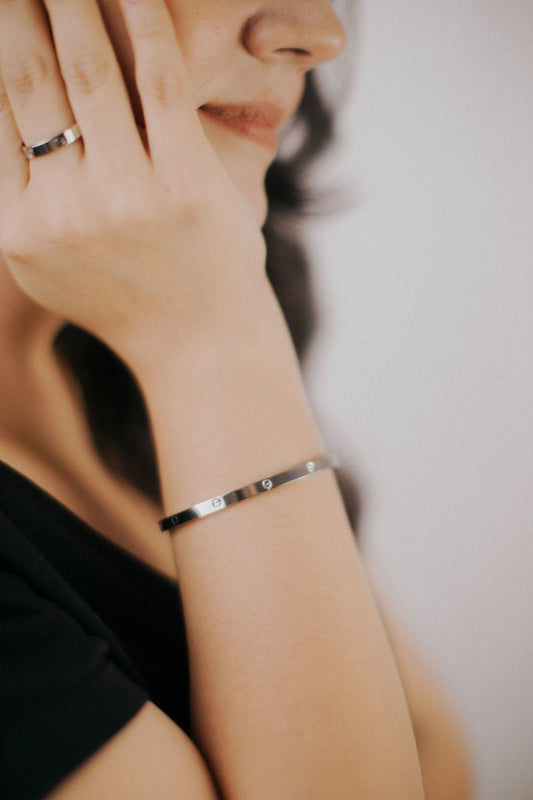 a woman wearing a silver bracelet and a black shirt