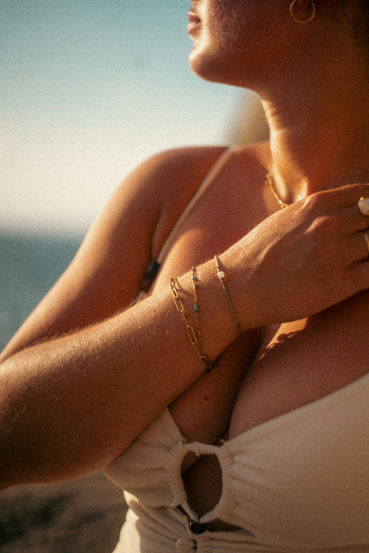 A woman in a white top is standing on the beach