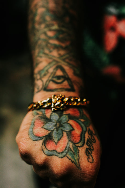 A person with a tattoo on their arm holding a chain