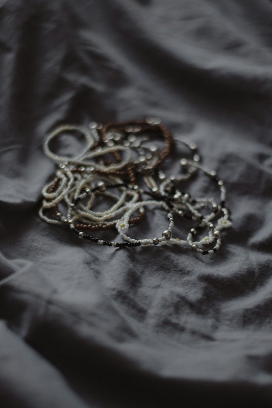 Bracelets and jewelry lie scattered on fabric.