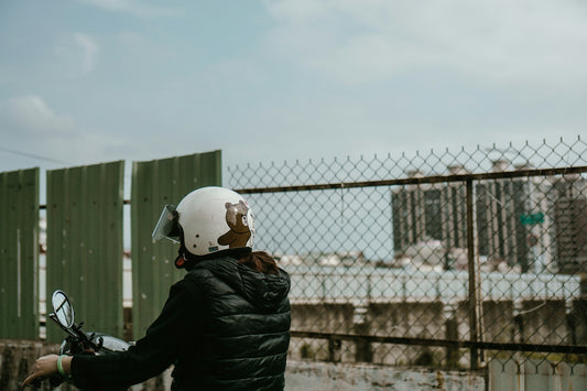 A person is wearing a helmet by the street.