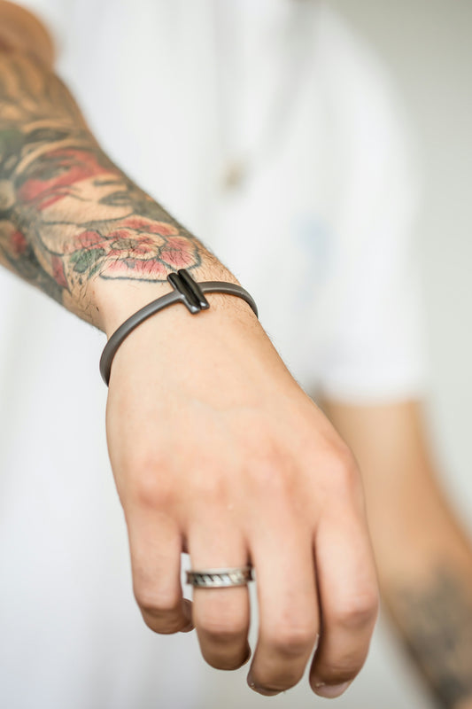 A man displays his bracelet and ring.