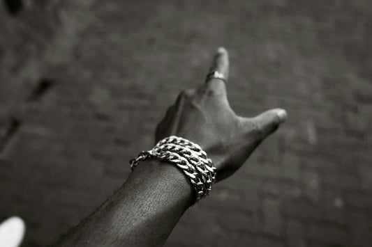 A hand with a bracelet points upwards