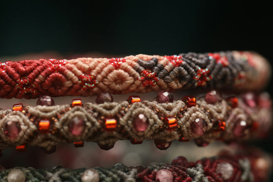 Close-up of stacked macrame bracelets with beads.