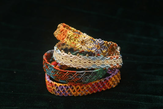 Stack of colorful woven bracelets on dark background