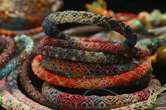 A stack of colorful, intricately woven bracelets
