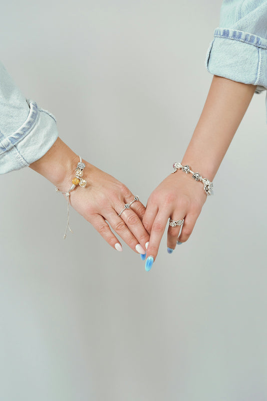 Two women holding hands with bracelets and bracelets