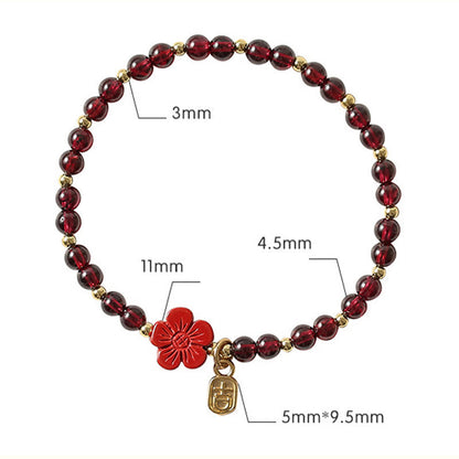 Pulsera Buddha Stones de oro de 14 quilates con flor de cinabrio y granate natural.