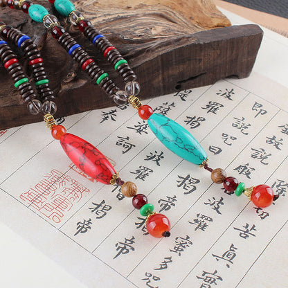 Collar con colgante de piedra turquesa, madera de wengué y piedras de Buda que protegen la calma.